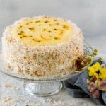 Passion fruit coconut cake with toasted coconut and passion fruit curd on cake stand