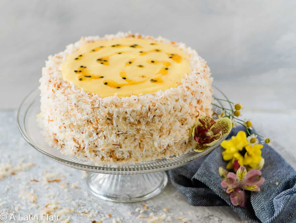 Passion fruit coconut cake with toasted coconut and passion fruit curd on cake stand