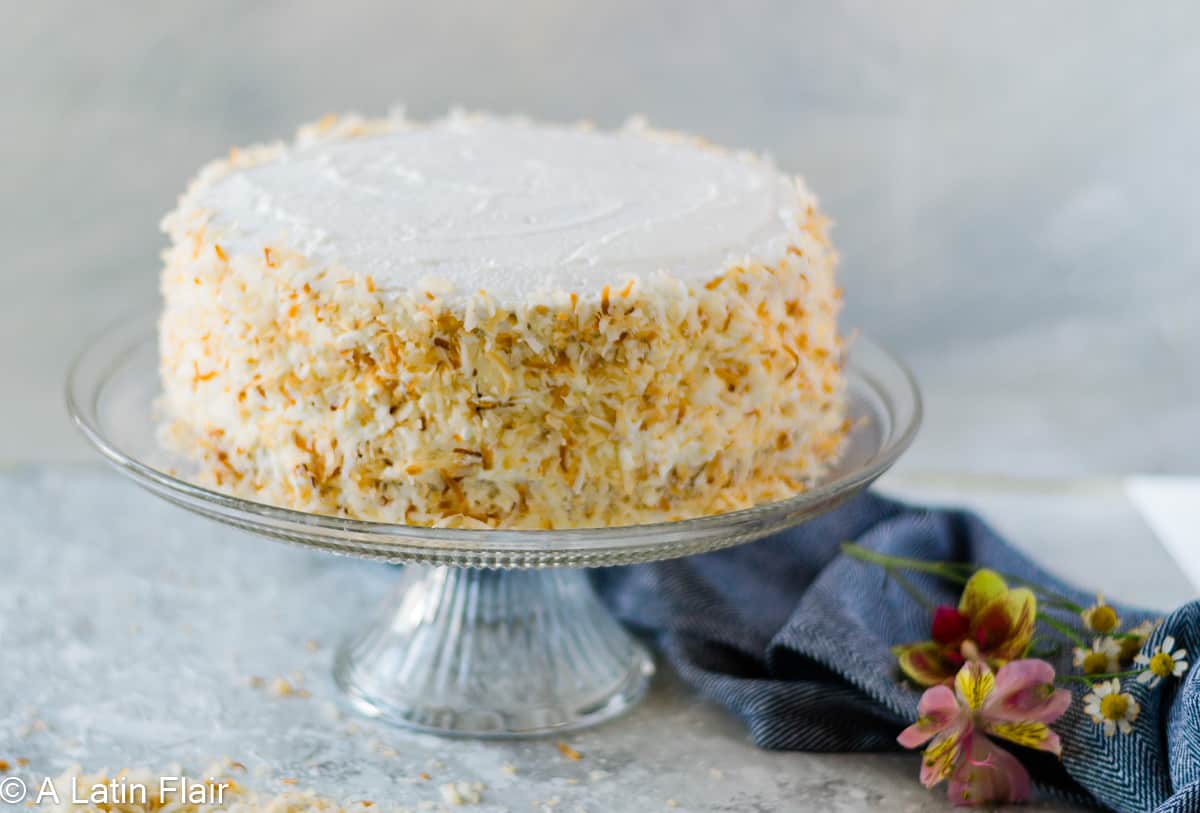 Passion fruit coconut layer cake decorated with toasted coconut on the sides