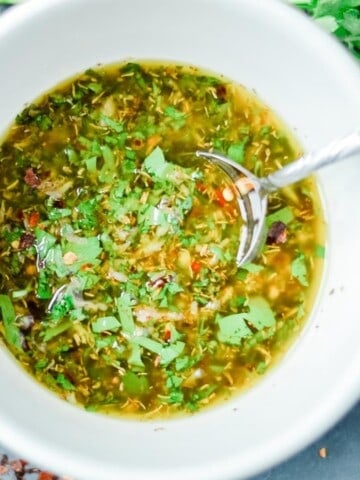 chimichurri-sauce-in-a-white-bowl-with-parsley around