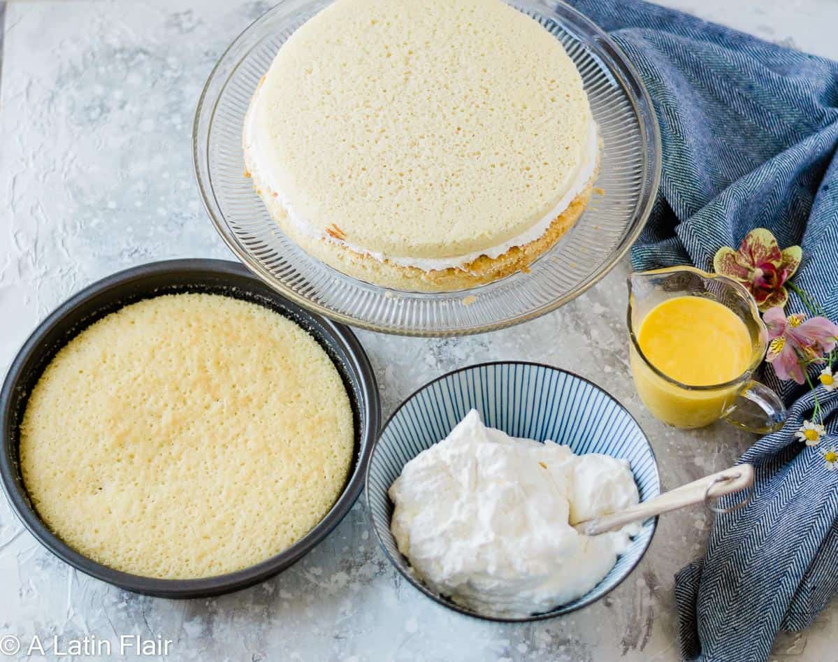 coconut cake being layered with whipped cream and passion fruit curd