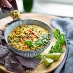 dipping-corn-chip-in-Elote-Corn-dip-with-poblano-peppers