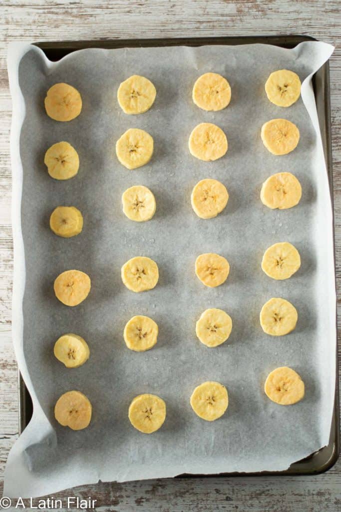 seasoned-green-plantains-slices-on-a-sheet-pan-for-Oven-Baked-tostones