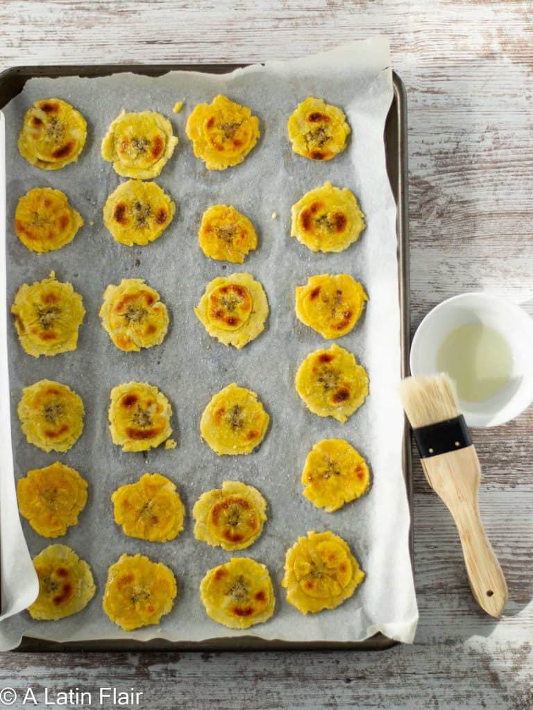 oil-brushed-tostones-chips-on-a-sheet-pan-for-re-baking