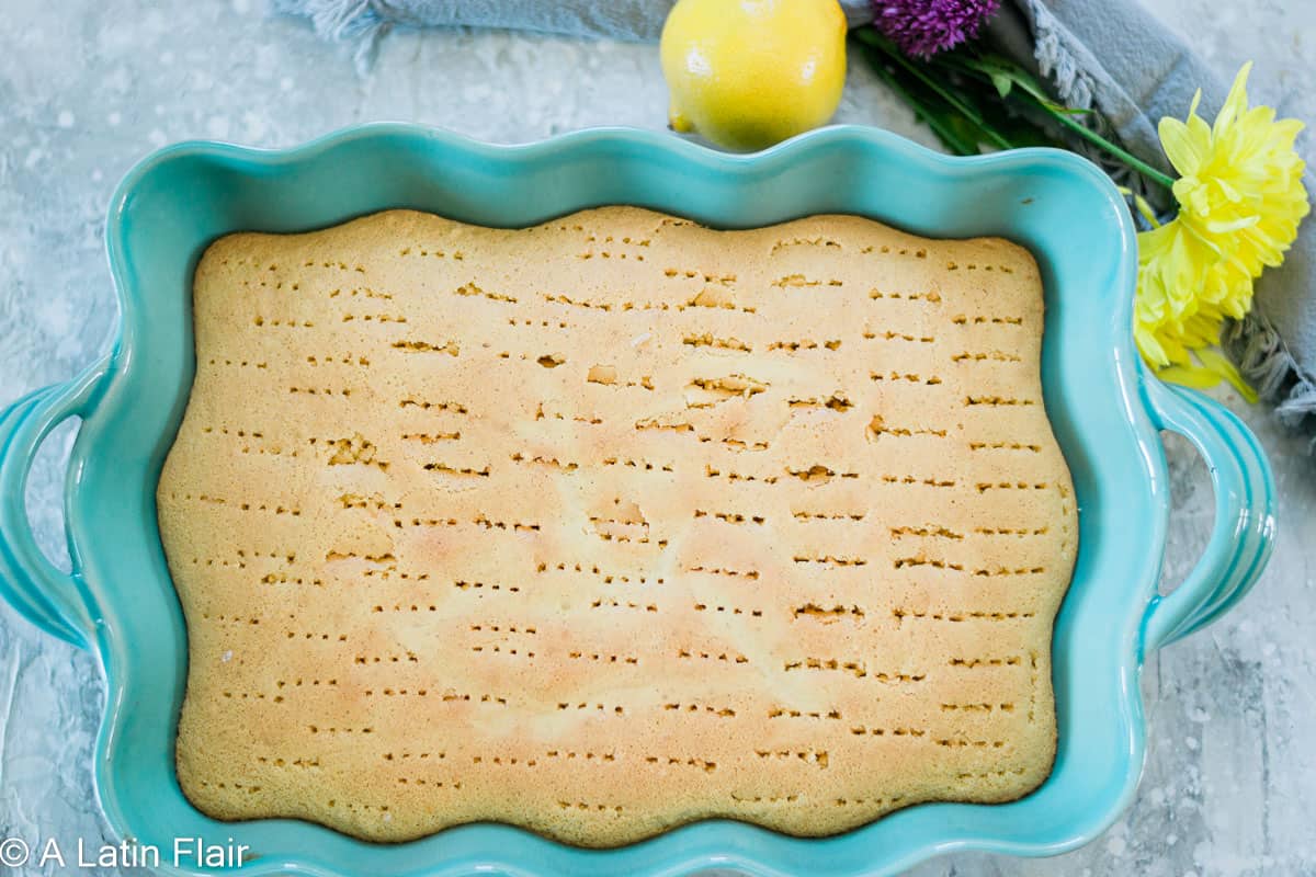 lemon-tres-leches-cake-with-holes-poked-in-blue-baking-pan