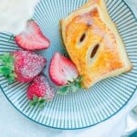 Pastelitos-de-Guayaba-close-up-served-on-plate-with-strawberries-and-coffee-and-flowers