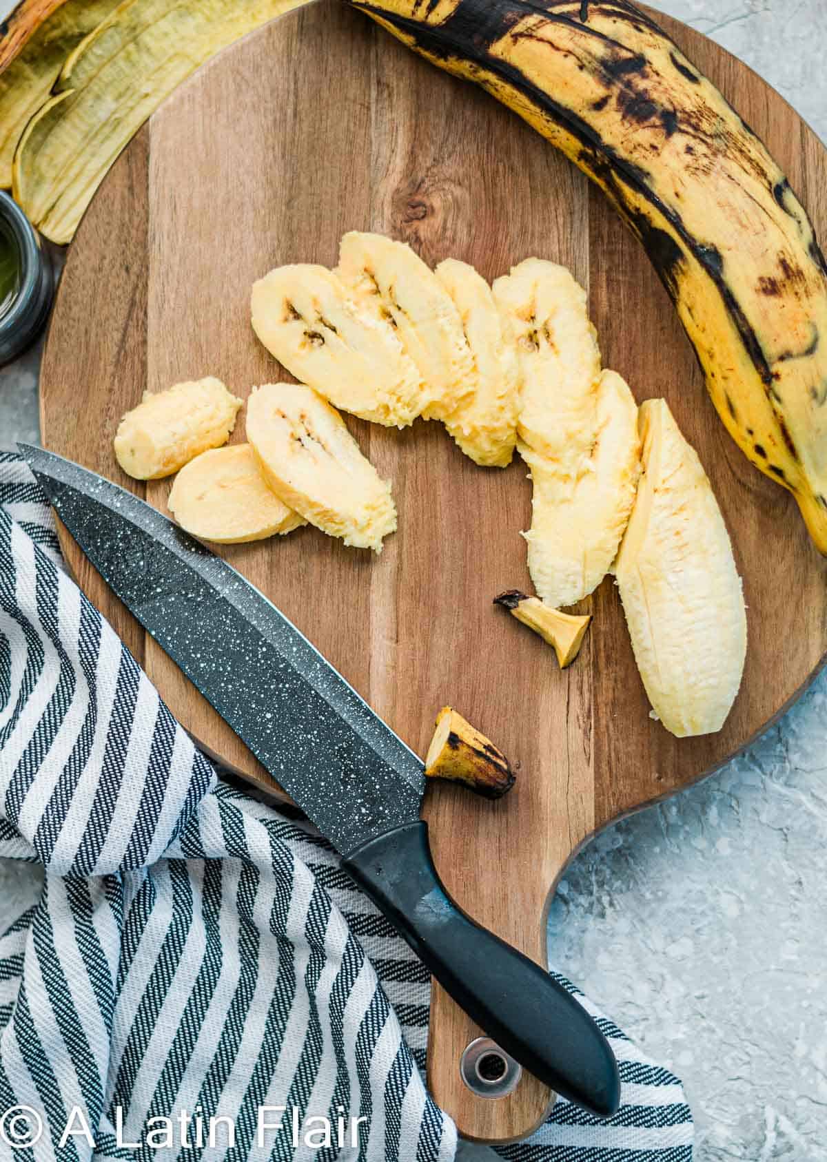 Ripe-yellow-Plantains-with-black-spots-peeled-and-sliced-on-cutting-board