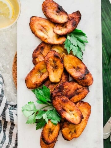 Sweet-Fried-Plantains-on-white-dish-and-plantain-leaf