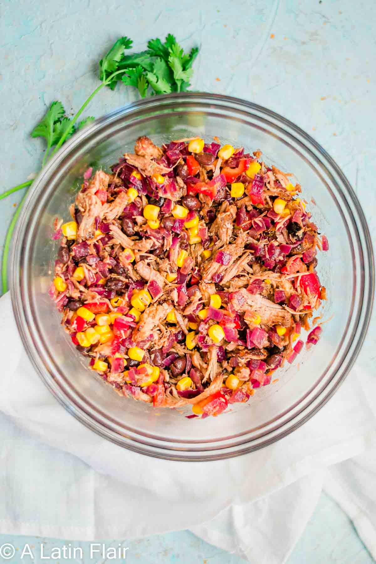 filling ingredients for quesadillas with leftover pulled Pork carnitas mixed in a glass bowl