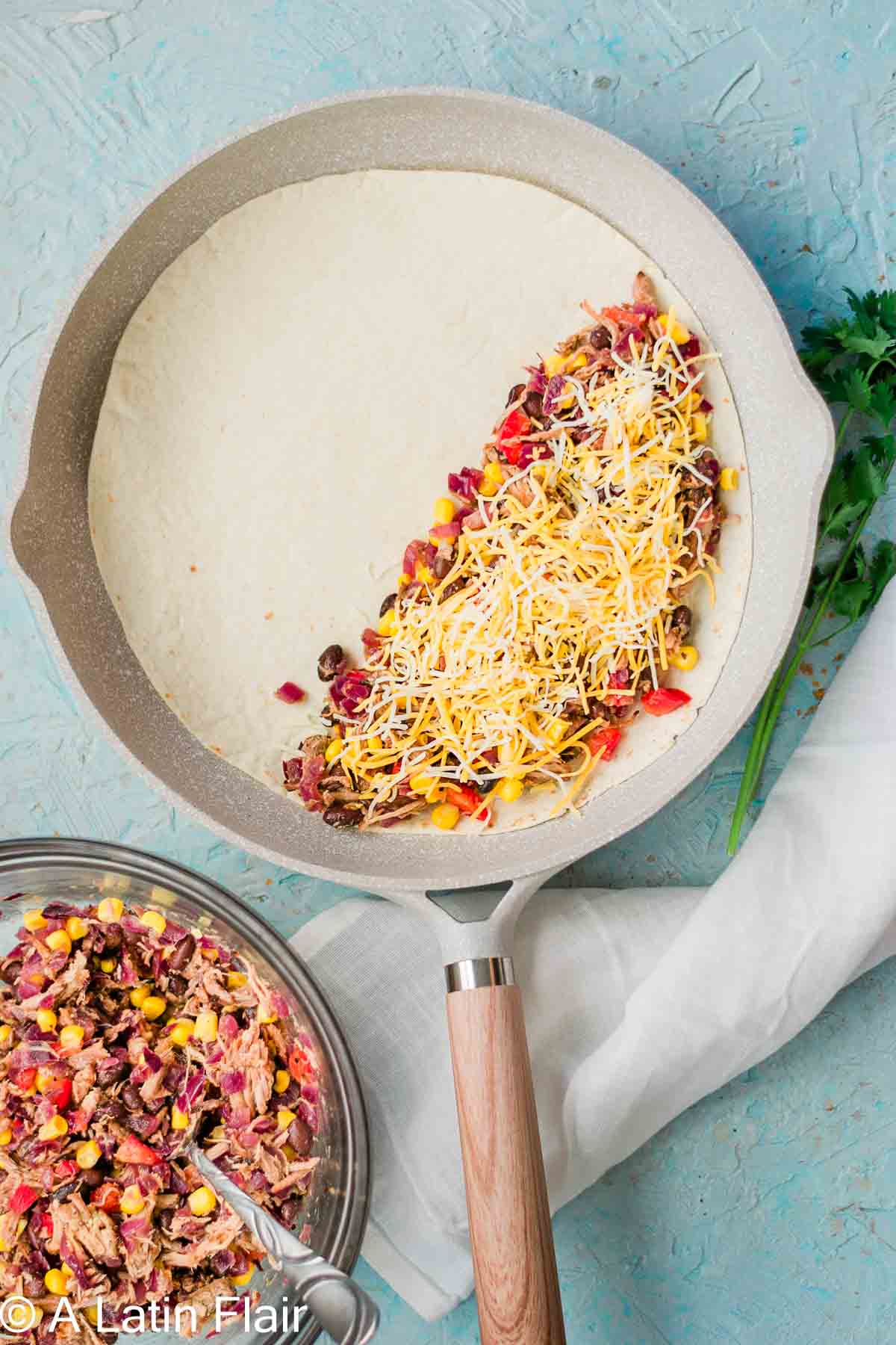 cooking quesadillas in a skillet filled with leftover pulled Pork carnitas filling and sprinkled with cheese 