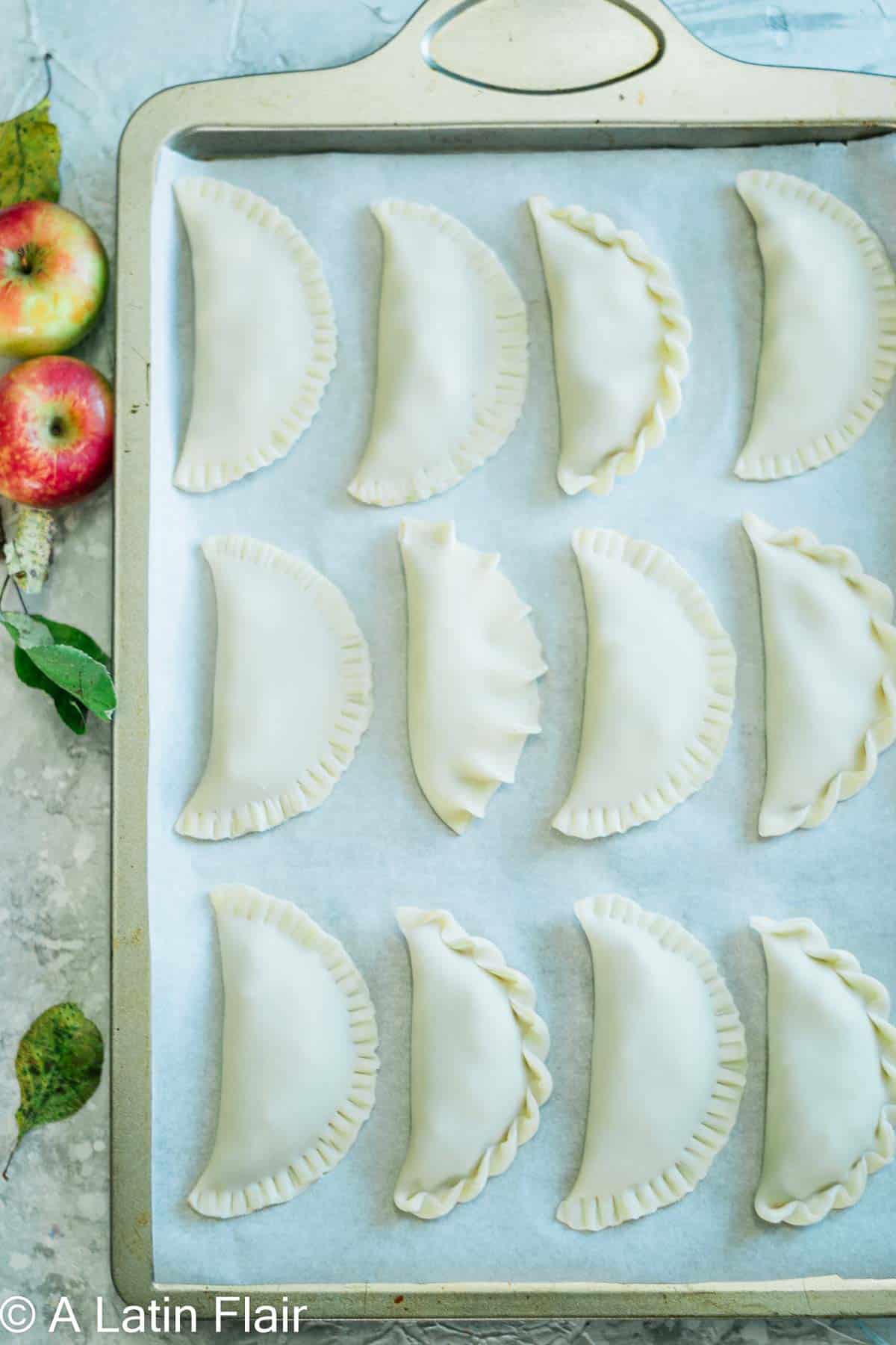 Dulce de Leche and Apple Empanadas arranged on sheet pan