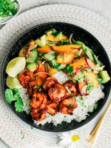 shrimp bowl recipe with rice and peach salad in black bowl