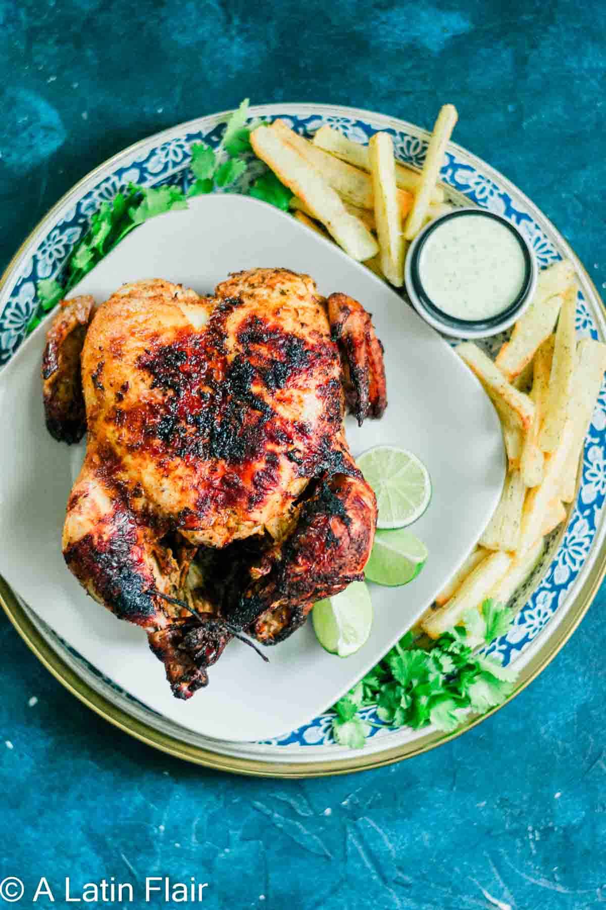 whole cuban pollo asado on white plate (chicken asado recipe) 