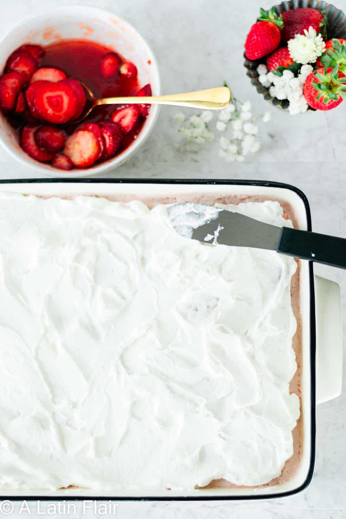 frosting a strawberry Tres Leches cake