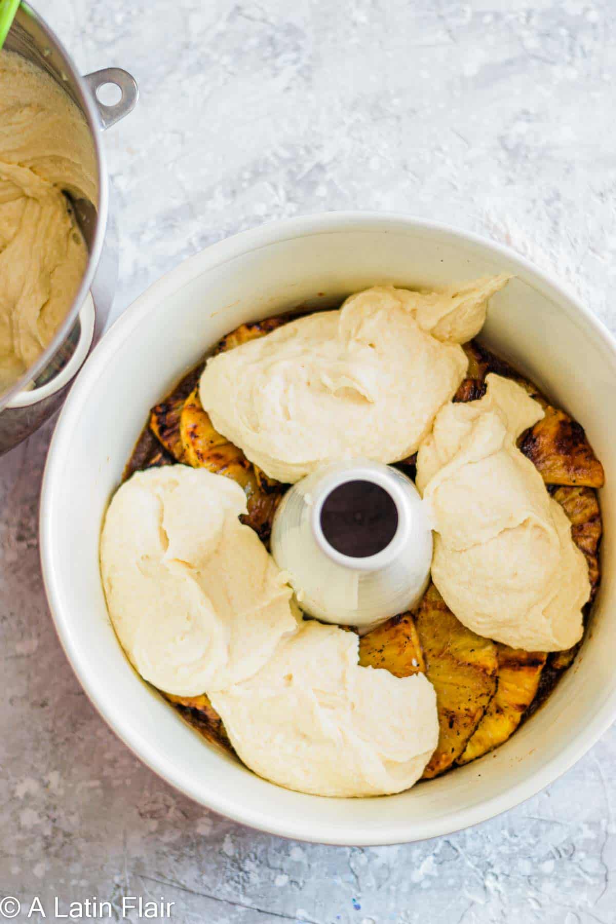layered pineapple slices and cake batter in cake pan for Upside Down Pineapple Rum Cake