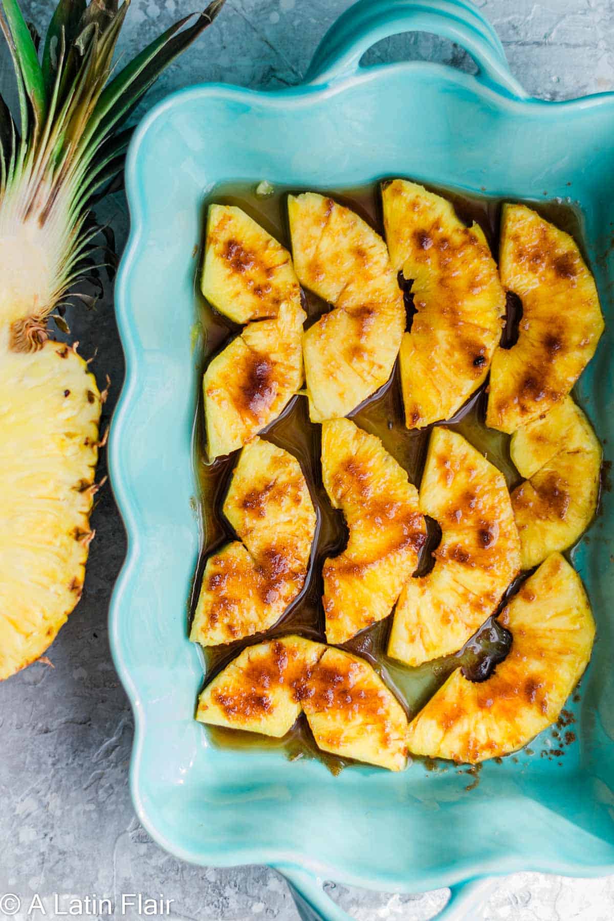 soaking sliced pineapple with rum and brown sugar 