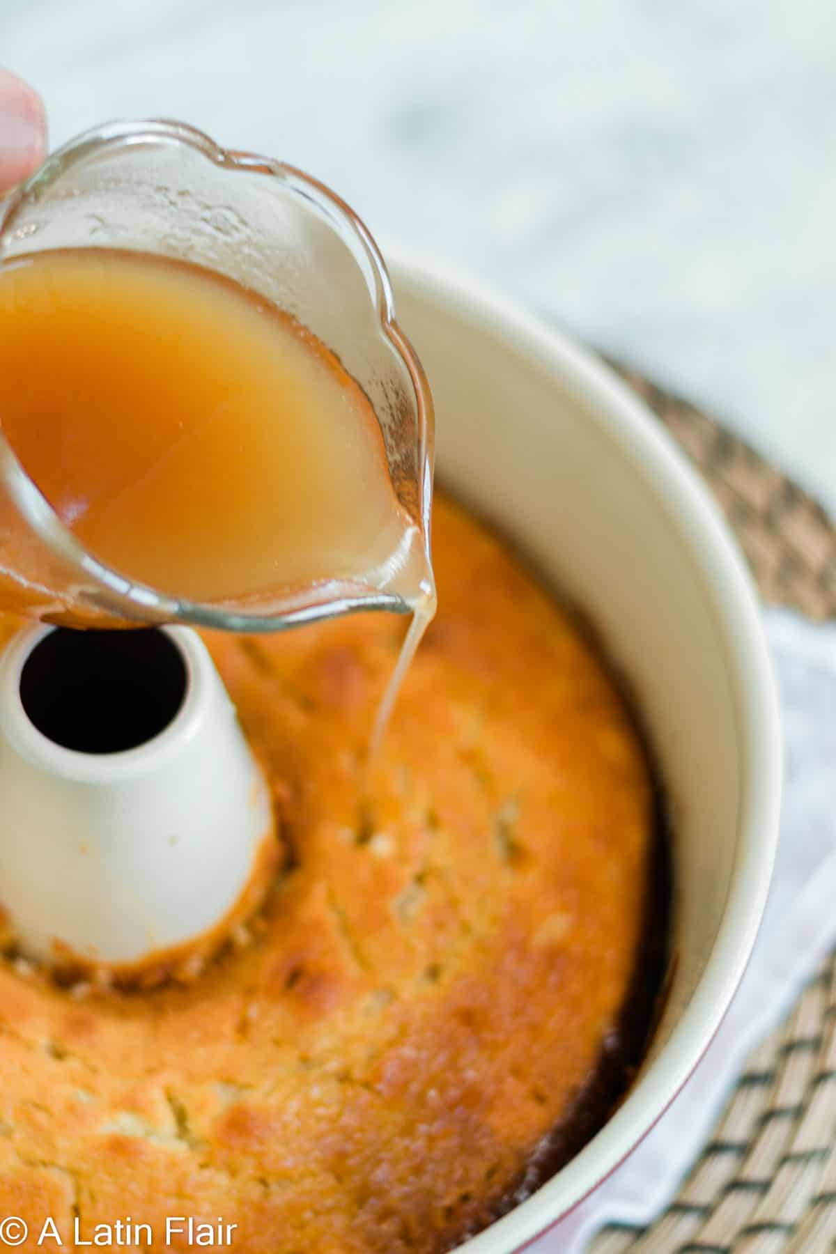 pouring rum syrup over baked rum cake