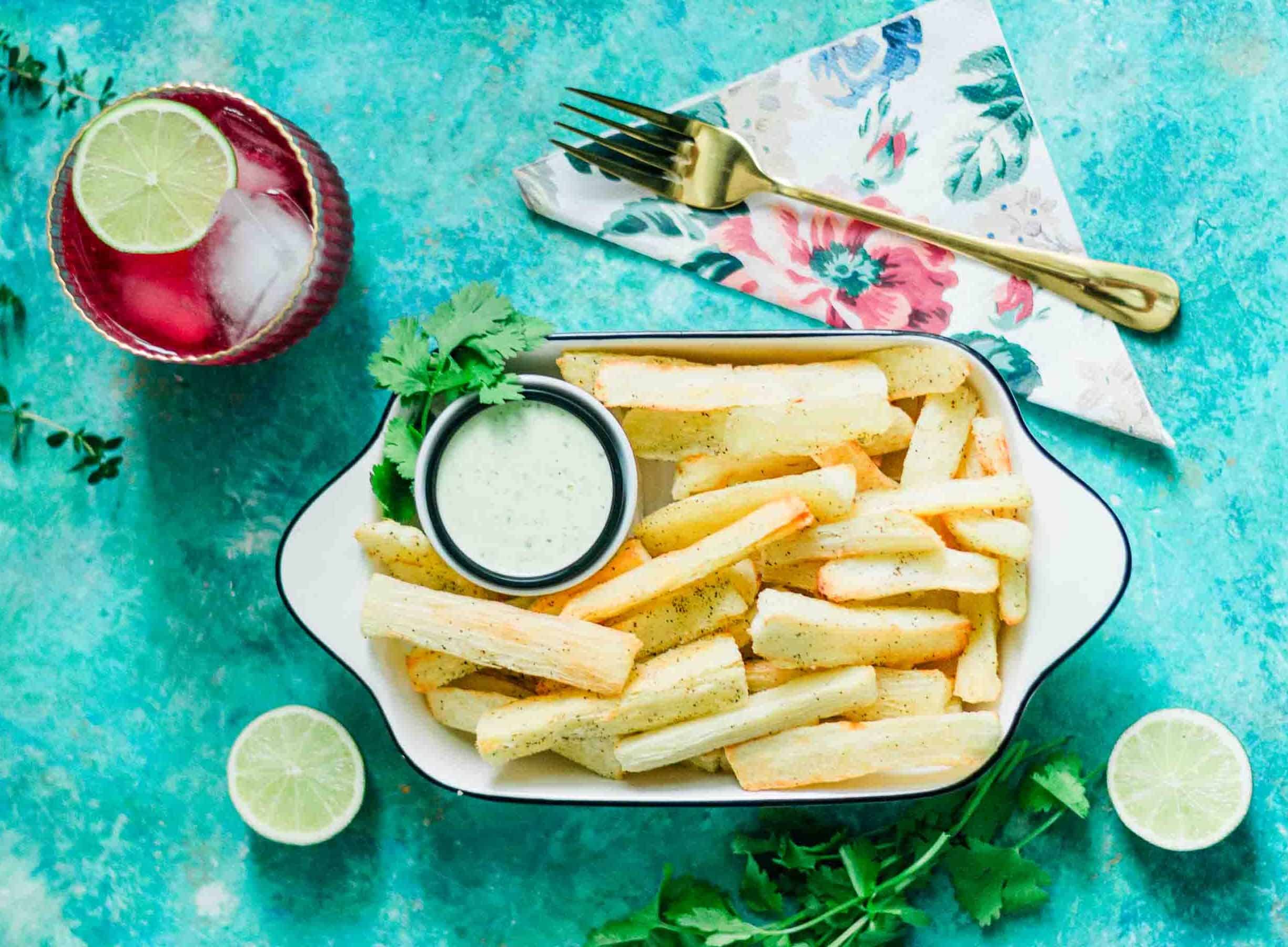 Yuca Fries made in the Air Fryer and served in a white bowl with Garlic Cilantro Lime Sauce