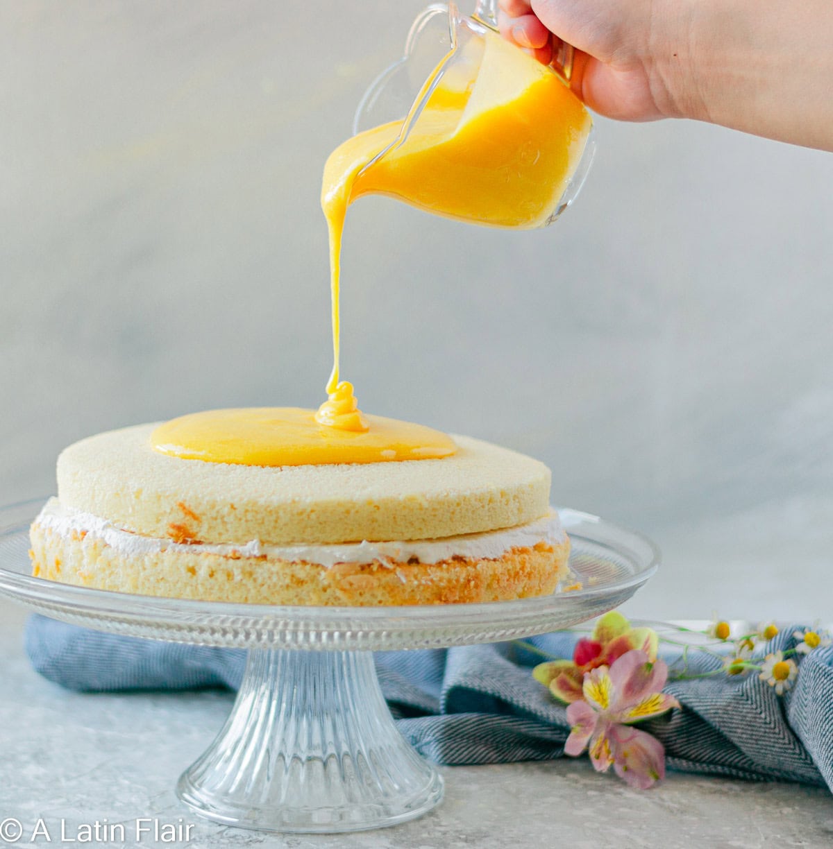 pouring passion fruit curd over a cake